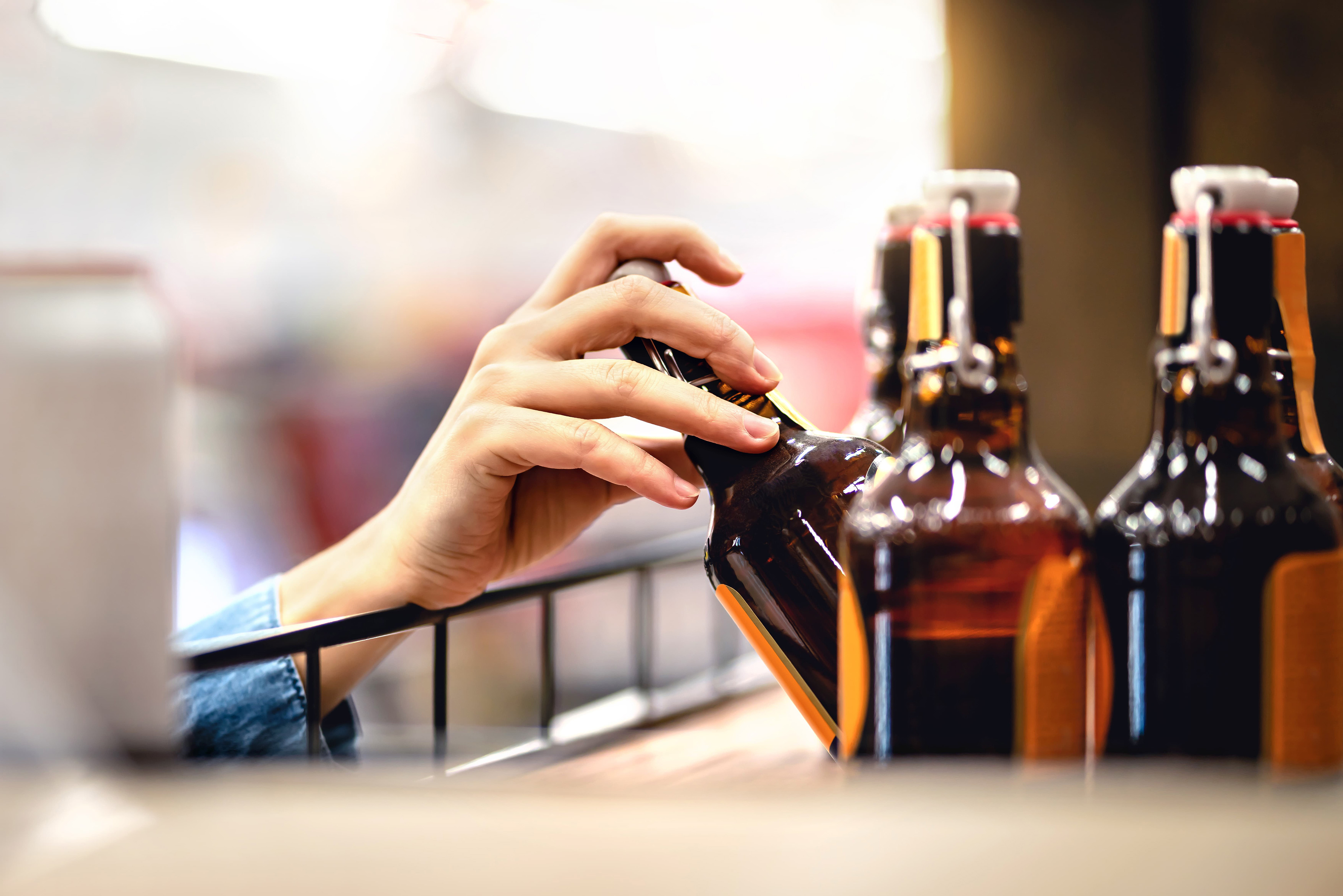 Persoon haalt bierfles uit het schap